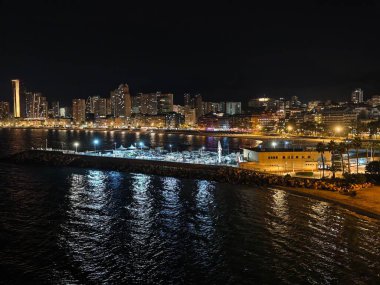 Canlı kıyı şeridi gece aydınlandı, parlak deniz kıyısı gece yansıtıcı yüzeyi ve hareketli