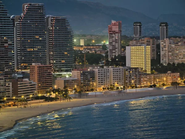 Liman ufku gün batımında ışıldıyor, günbatımı sakin sahil üzerinde parlayan liman silüetiyle.