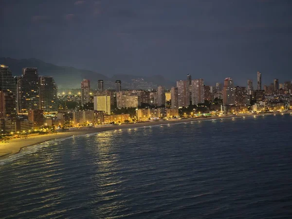 Alacakaranlıkta geniş bir kıyı şeridi, alacakaranlıkta engin kıyı manzarası aydınlık gezinti güvertesi ve sakin sörf ile