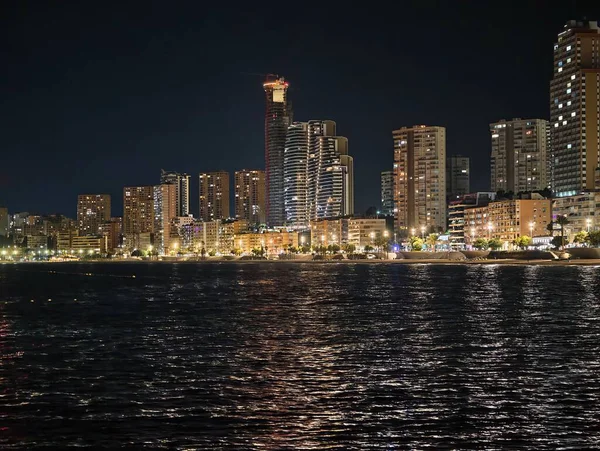 Canlı kentsel ufuk çizgisi sakin suları renkli yansımalar ve canlı yansımalarla aydınlatıyor 