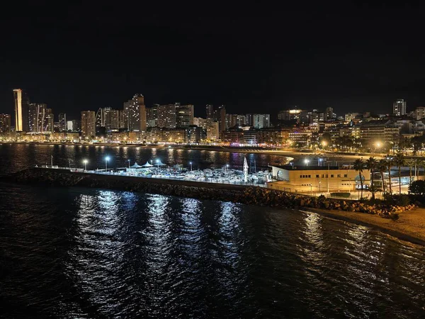 Canlı kıyı şeridi gece aydınlandı, parlak deniz kıyısı gece yansıtıcı yüzeyi ve hareketli