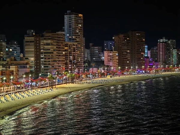 Aktif gece koşucularıyla aydınlık sahil yolu, aydınlatılmış sahil gezintisi