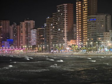Parlak şehir kıyı şeridiyle parlak bir gece, renkli neon ışıklarla aydınlatılmış canlı şehir gezinti güvertesi.