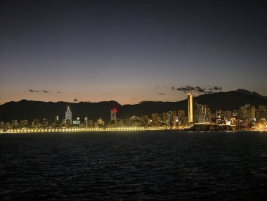 Parlayan yapılarla sakin kentsel manzara, sakin kıyı şehri gökyüzü yansımalarının altında ufuk çizgisi