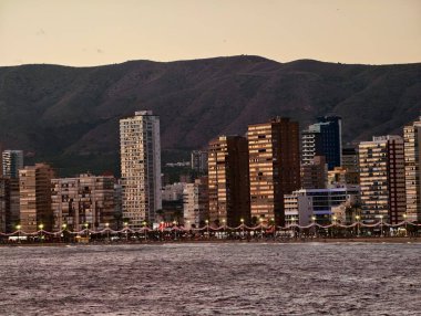 Huzurlu sahil manzarası, sakin sahil kasabası altın saatinde dağ manzaralı ve yumuşak deniz manzaralı