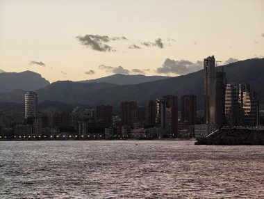 Sakin alacakaranlık kıyı şeridi, sakin rıhtım manzarası alacakaranlık sırasında dağ siluetleriyle