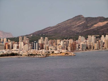 Gün batımı şehir manzarası yansıması, bu gece sakin liman sahnesi, bulutların yumuşak çizgileri ve yansımaları ile.