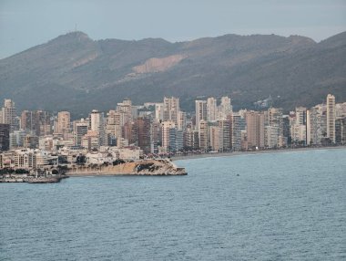 Sarp kayalık oluşumları sakin kıyı şeridini çizerken konut yapıları doğal yapılarla harmanlanır.