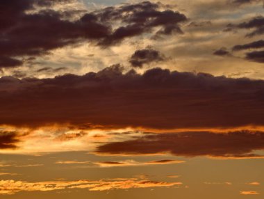Sakin okyanus üzerinde dramatik bir gökyüzü, yoğun günbatımı kızgın bulutlar ve barışçıl bulutlarla aydınlatan gökyüzü.