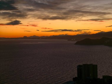 Karanlık çöktüğünde canlı kıyı şeridi, çarpıcı günbatımı ve karamsar atmosfer etkileriyle şehir kıyısı