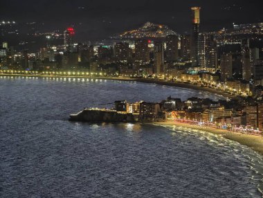 Canlı ışıklarla dolu gece limanı, canlı sokakları ve deniz faaliyetleriyle aydınlık körfez alanı