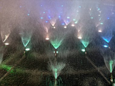 Parlak su jetleri neşeli bir şekilde parlar, senkronize uçaklar ve sis canlı bir kutlama sahnesi yaratır.