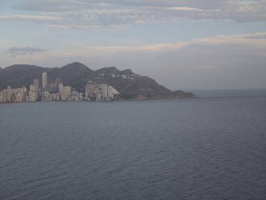 Huzurlu kıyı manzarası, sakin kıyı şeridi sakin suları ve yumuşak gökyüzü arkaplanı olan gökyüzü.