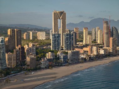 Şehir plajının sabah manzarası, canlı şehir üzerinde gün doğumu ticari ve deniz manzarası