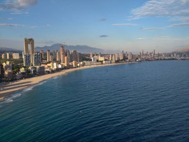 Canlı sahil manzarası, hareketli marinası ve ışıltısıyla canlı kıyı şehri.