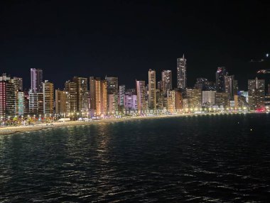 Huzurlu gece deniz manzarası aydınlık gökdelenler ve görsel yansımalar