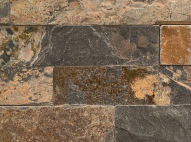 Kırsal taş süsleme, düz olmayan taş yüzey sıcak kahverengi renklerde mineral içeriyor.