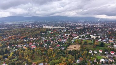 Yeşillik ortasındaki inşaat alanları, yol ve arazilerle hava manzaralı kentsel genişleme