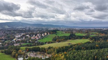 Tepelerin ve ağaçların manzarası, uzak dağların ve kırsal alanların geniş hava manzarası.