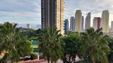 Bereketli kıyı sporları, kıyı boyunca yemyeşil bitki örtüsü spor alanlarıyla ve yükselen kentsel alanlarla birleşmiş.