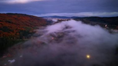 Hava görüntüleri, alacakaranlık saatlerinde renkli sonbahar sırtlarında zikzak çizen hayalet sisi yakalar.