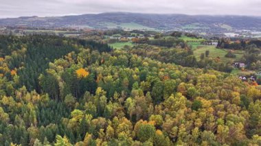 Bulutlu sonbahar gökyüzünün altındaki uzak tepeler, dinamik hava çekimi doğayı ve mevsimleri gözler önüne seriyor.