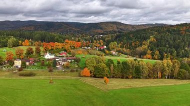 Parlak ağaçlarla dolu manzaralı bir kırsal bölge, cennet gibi uluyan tepeler ve ekili araziler.