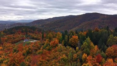 Renkli tepe kenarı köy manzarası, dağınık konutlar ve hareketli manzaralı kırsal bölge.