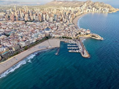 Marina kümesi ve çevresel çatıları, şebeke caddeleri ve liman kıyısı olan yoğun kıyı bölgesinin hava manzarası