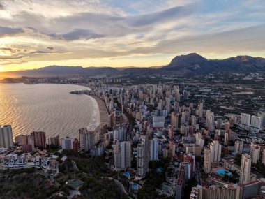 Karanlık şehir manzarası, dağ zeminiyle şehir içi banliyö manzarası şehir ışıkları ve deniz manzarasıyla aydınlatılıyor.,