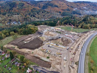 Ormanlı tepenin yanındaki hava yolu genişlemesi, inşaat halindeki eğimli kaldırım, toprak seti derecelendirme