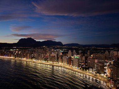 Sakin kıyı şeridi boyunca altın saat ufuk çizgisi sıcak ışıklar gezinti güvertesi, yumuşak bulutlar siluet üzerinde çizgiler