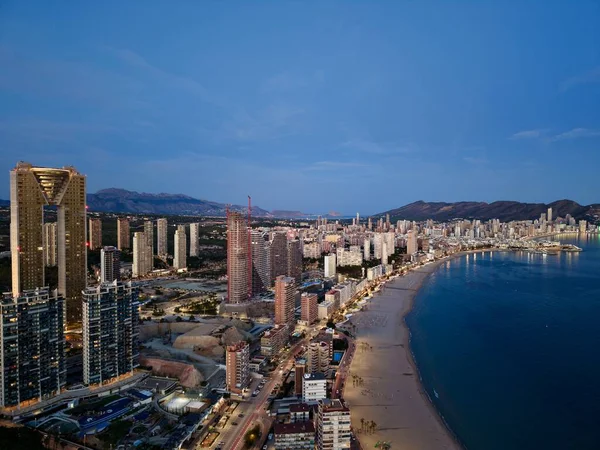 Sahile bakan lüks tavan çizgisi ve cam kuleler, parıldayan ışıklar ve teraslar yaratıyor.