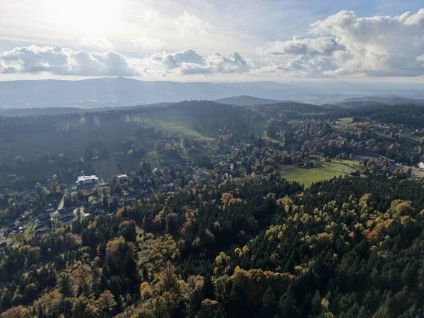 Hava manzaralı kasaba ormanı sonbahar renklerinin kenarına saçılmış evler ve dolambaçlı yollar, karışık bir topluluk.