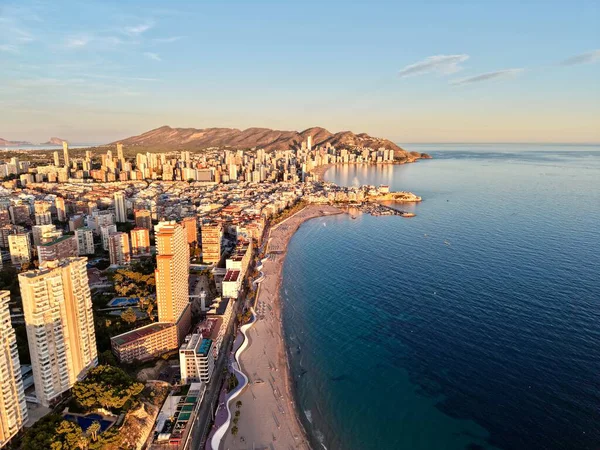 Gün batımı kıyı şeridi ufuk çizgisi sıcak, yaşam tarzı tetikçisi suya turuncu yansımaları yakalıyor.