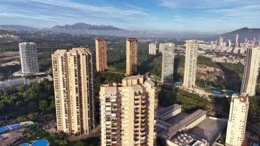 Dağ Arkaplanı ve Çamları olan Şehir Kuleleri Yeşil Vadi 'ye bakan uzun apartman blokları, Uzak Tepe