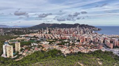 Hava Sahil Kenti Panorama Bulutlu Gökyüzü Yeşil Önplanı ile Hillside, Bay ve Yoğun Binaları Gösteriyor