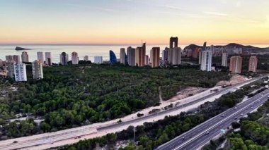 Yeşil Orman 'dan geçerek Skyline' a doğru giden otoyol gün batımında, çok şeritli yol, yumuşak akşam ışığı, ağaç...