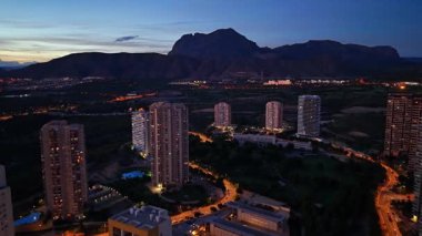 Aydınlatılmış kuleleri ve bulvarı olan alacakaranlıktaki Gece Yükselişi Oteli Yöneticisi