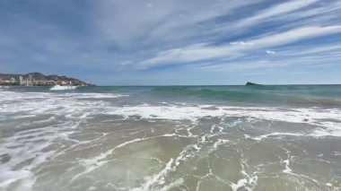 Güçlü dalgalar Kum Kıyısı 'na çarpıyor Beyaz köpükle, Turkuaz dalgaları Kameraya doğru ilerliyor, Canlı Mavi