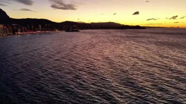 Dusk Bay Rıhtım Aracı Parıldayan Dalgaları Yakalıyor Ve Şehir Işıkları Sahil boyunca, Sıcak Altın Gökyüzü