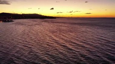 Günbatımı Dalgalanan Deniz Marina Siluetleri ile Liman Kıyısına yaklaşıyor, Sıcak Kehribar Gökyüzü ve Hafif Rüzgar