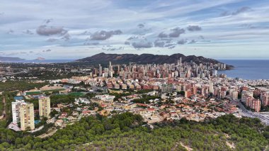 Hava Sahil Kenti Panorama Bulutlu Gökyüzü Yeşil Önplanı ile Hillside, Bay ve Yoğun Binaları Gösteriyor