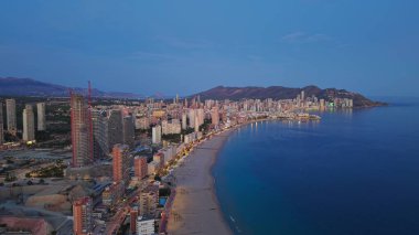 Mavi Saatteki Hava Kıvrımlı Sahilleri Uzun Sahil Hattı, Nazik Dalgalar ve Aydınlatılmış Gezinti Alanı İdeal