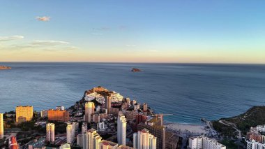 Sahil şehrinin ufuk çizgisi, günbatımında gökyüzü manzarası, yüksek binalar, Horizon 'daki küçük adayla Crescent Körfezi' ni kucaklıyor.