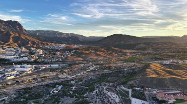 Sunset, Sunlit Ridges ve Arid Vadileri 'ndeki Aerial Mountain Foothill kasabası.