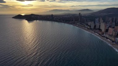 Günbatımı Körfezi Eğrisi Parlak Suyla ve Altın Yansıması ile Hilal Sahili Siluetli Skyline ile,