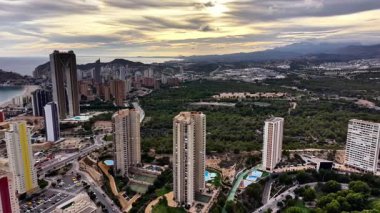 Kıyı Yükseliş Kulelerine, Virajlı Yollara, Yeşil Parkland 'a bakan dramatik Günbatımı Şehir