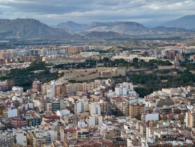 Engebeli dağ zeminli, desenli taş duvarlı, geniş şehir manzarasına bakan tarihi Kale
