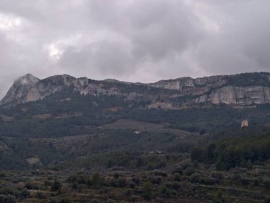 Kara kara düşünen Bulutlu Kefen Dağları Orman Vadisi, Katmanlı Sırtlar ve Ağır Altında Sessizleştirilmiş Sesler
